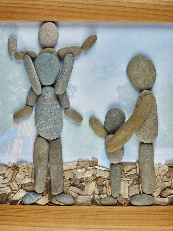 Steinbild, Bild aus Steinen, Familie Eltern mit ihren Kindern am Spielplatz im Rindenmulch